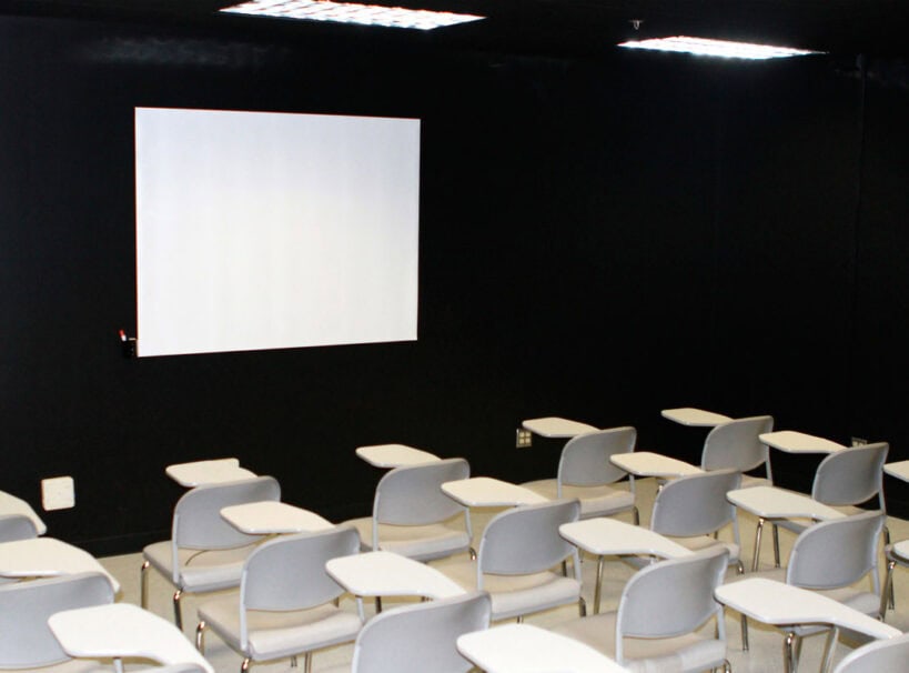 Projection Screen for Presentations Projection screen with classroom setup for presentations and training.