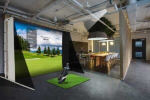 Portable golf simulator screen with projector setup in modern indoor space.