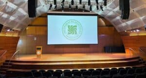 Large projector screen in a modern auditorium setting.