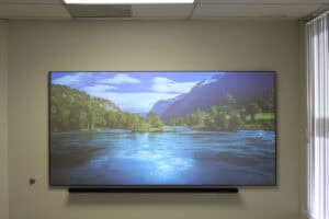 Large commercial-grade projector screen displaying a scenic river landscape.